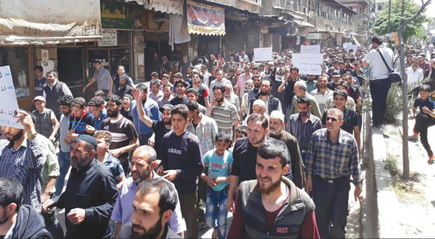 متظاهرون في غوطة دمشق الشرقية خرجوا أول من أمس احتجاجاً على القتال بين فصائل المعارضة في المنطقة (إ.ب)