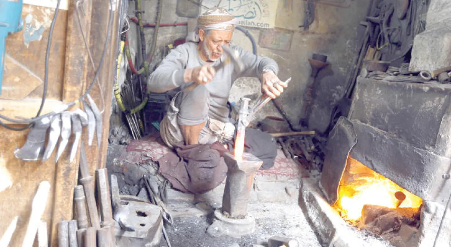 يمني يعمل داخل ورشة حدادة في المدينة القديمة بصنعاء (أ.ف.ب)