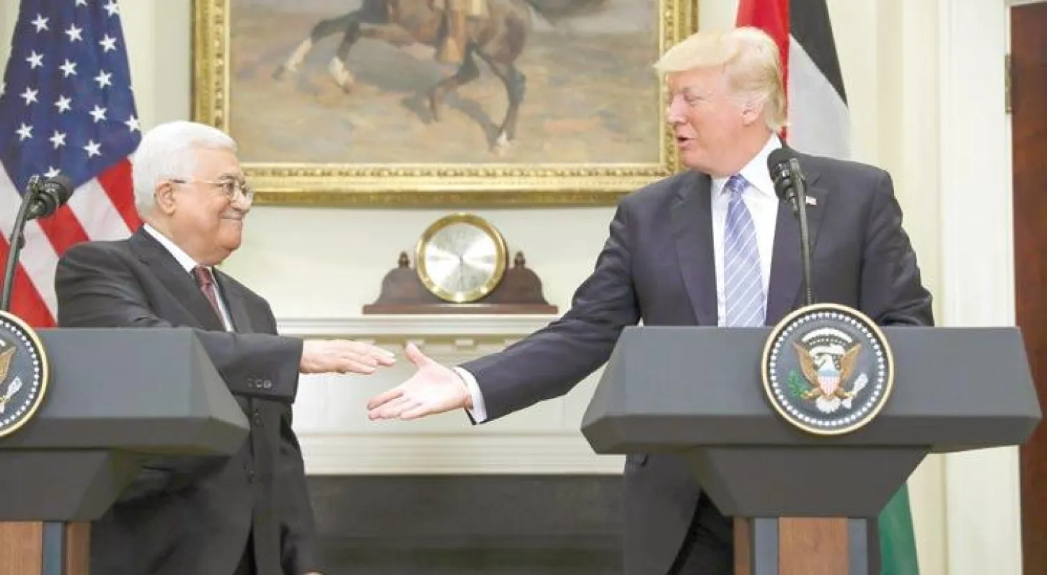 ترمب يصافح عباس لدى لقائهما في البيت الأبيض أمس (أ.ب)