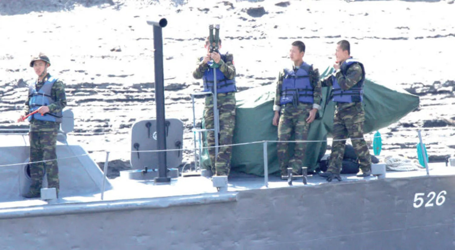 جنود من كوريا الشمالية على متن زورق حربي في نهر يولو قريباً من الحدود الصينية (رويترز)