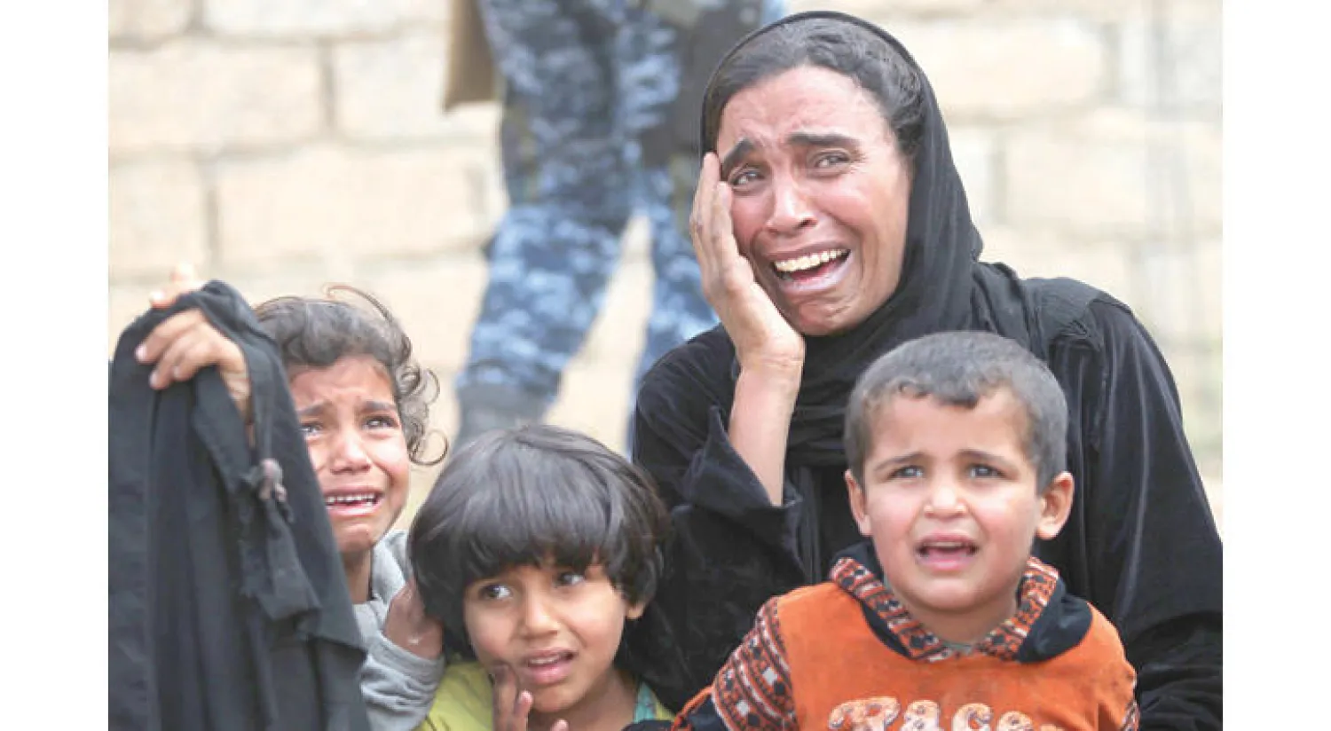 أم وأطفالها يبكون بعد نزوحهم من منزلهم في الهرمات شمال الموصل جراء المعارك بين القوات العراقية و«داعش» أمس (أ.ف.ب)