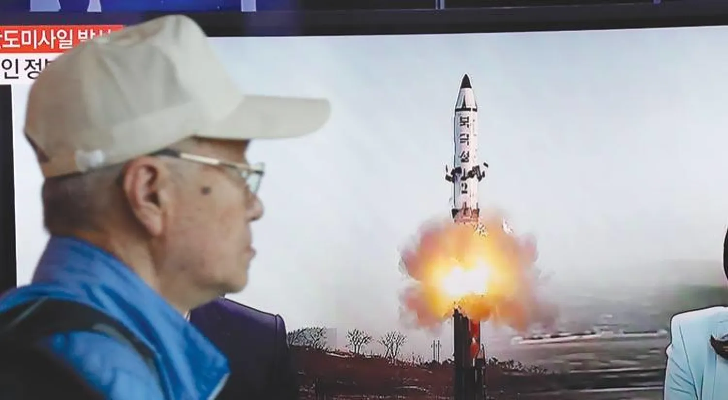 مواطن من كوريا الجنوبية يتابع عبر التلفزيون تفاصيل تجربة إطلاق الصاروخ الباليستي أمس (إ.ب.أ)