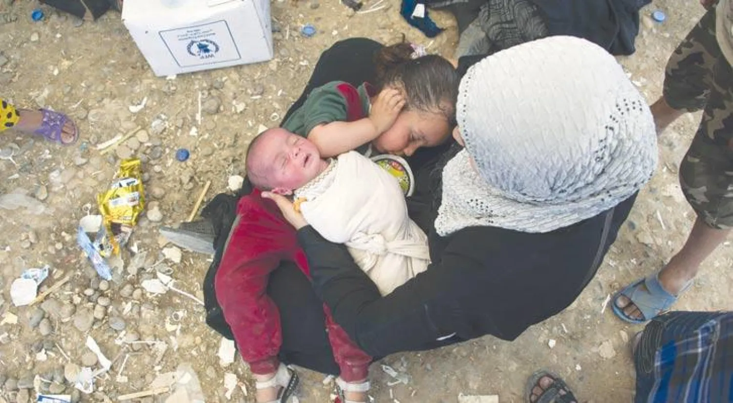 نازحة وطفلاها في مخيم حمام العليل (أ.ف.ب)