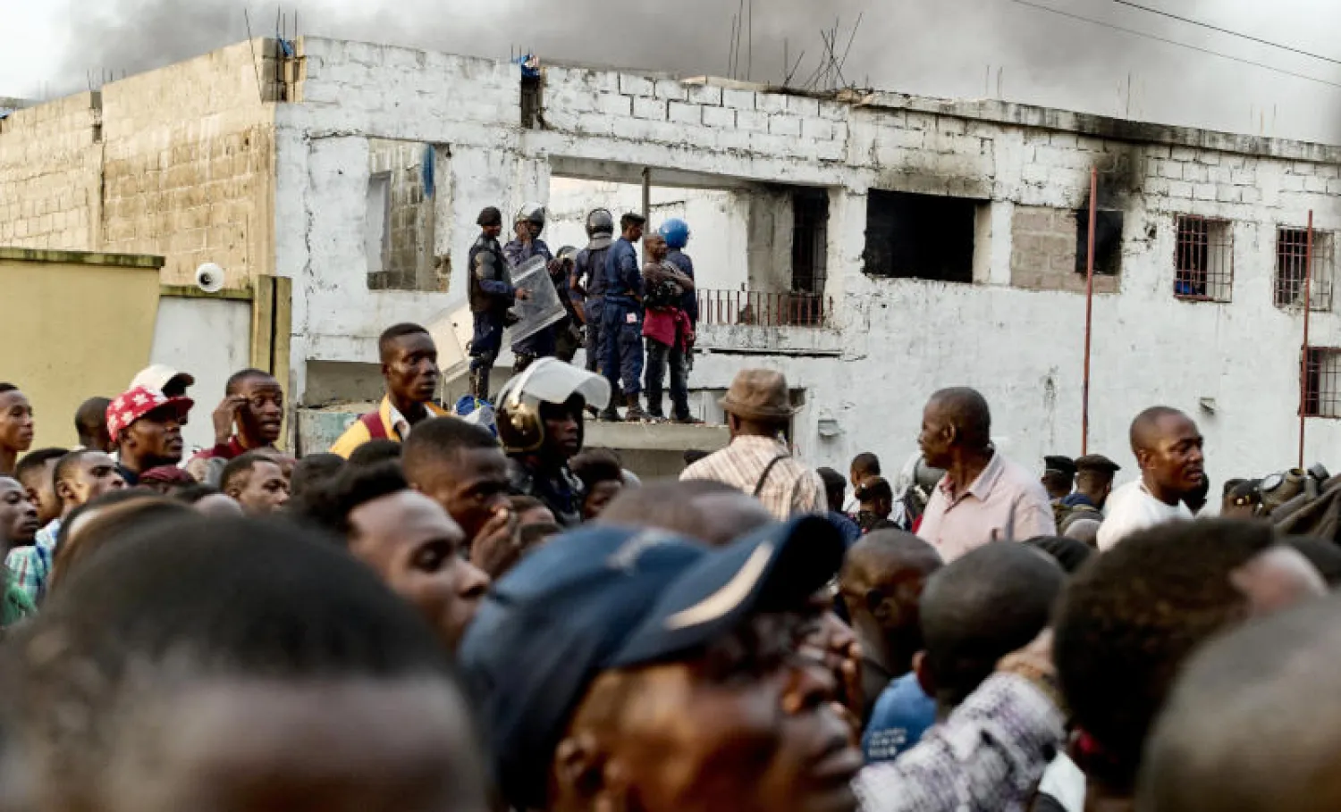 أنصار نسيمي يتابعون عملية أمنية قرب منزله في مارس الماضي (رويترز)