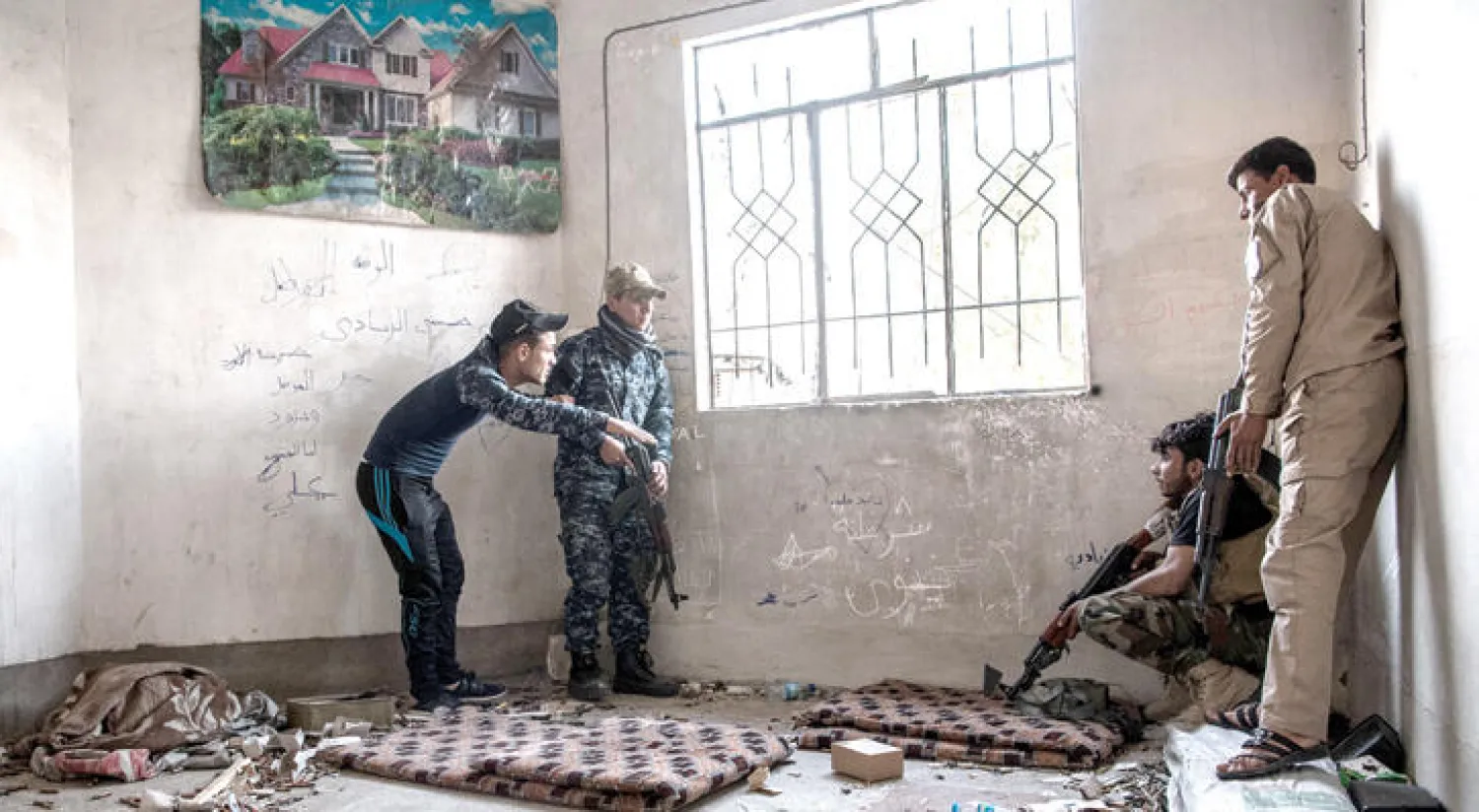 عناصر من الميليشيات المدعومة من إيران في أحد بيوت الموصل أثناء معركة غرب المدينة مع {داعش} (غيتي)