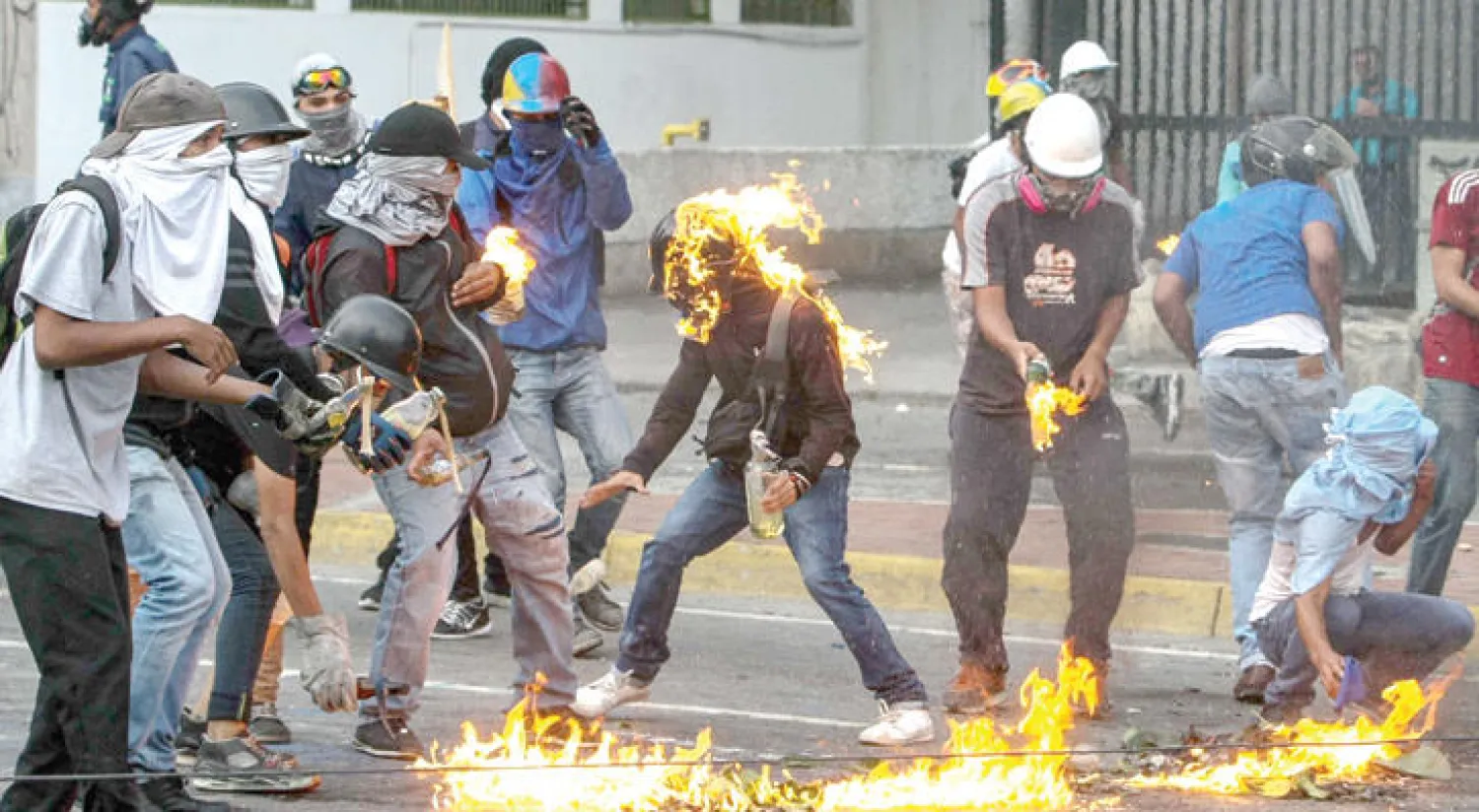 متظاهرون يستخدمون قنابل المولوتوف خلال اشتباكات مع قوات الأمن في كاراكاس أول من أمس (إ.ب.أ)