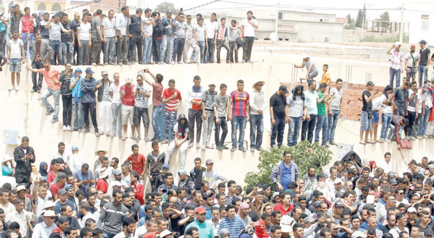 آلاف المحتجين أمام منزل القتيل الذي توفي خلال الاحتجاجات في مدينة تطاوين (رويترز)