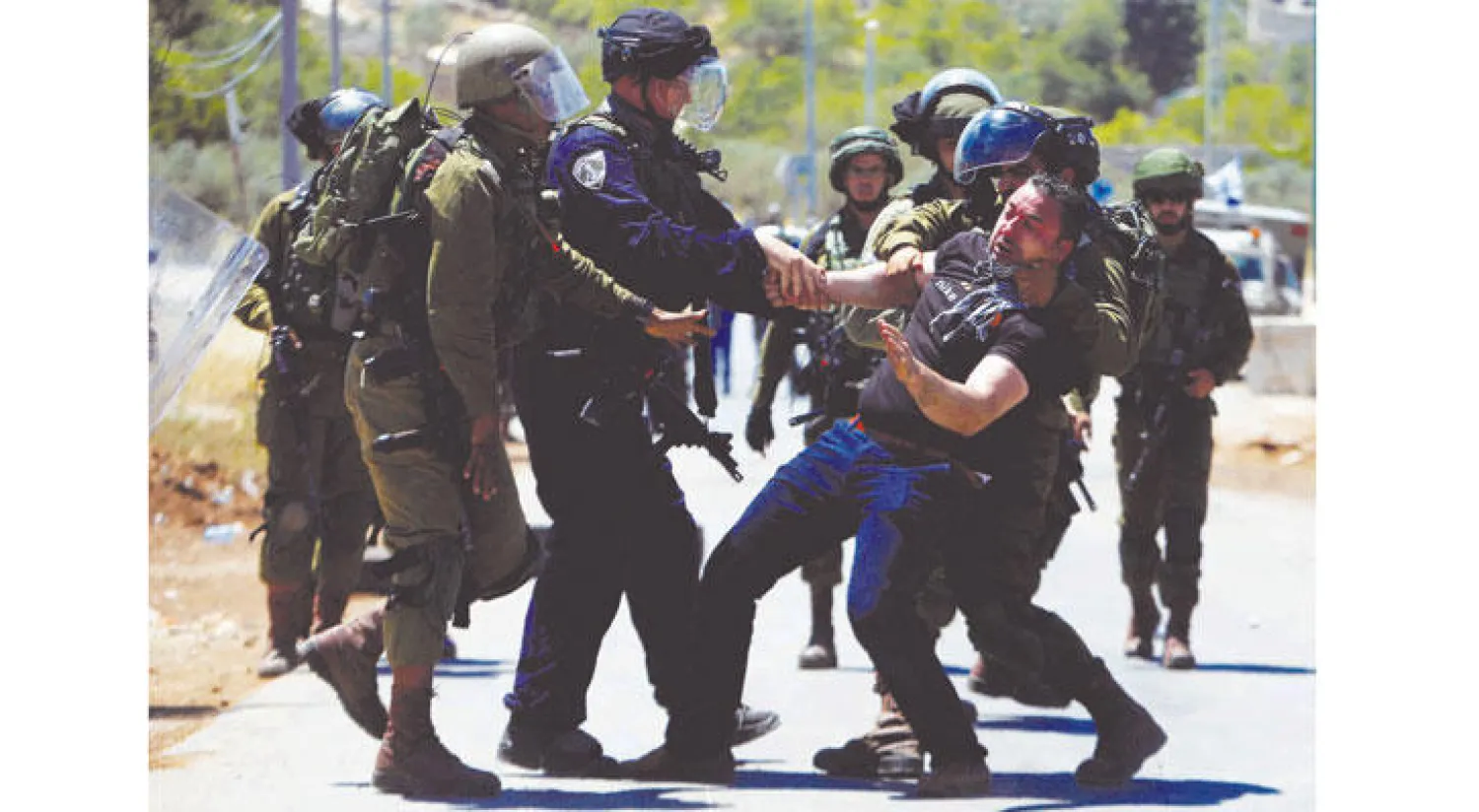 عناصر من الجيش الإسرائيلي يعتقلون فلسطينيا أثناء مظاهرة لتأييد الأسرى المضربين في قرية بيتا بالضفة أمس (رويترز)
