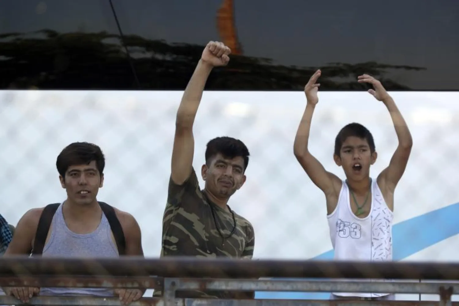 بعض اللاجئين أثناء إخلاء المخيم في اليونان (أ.ب)