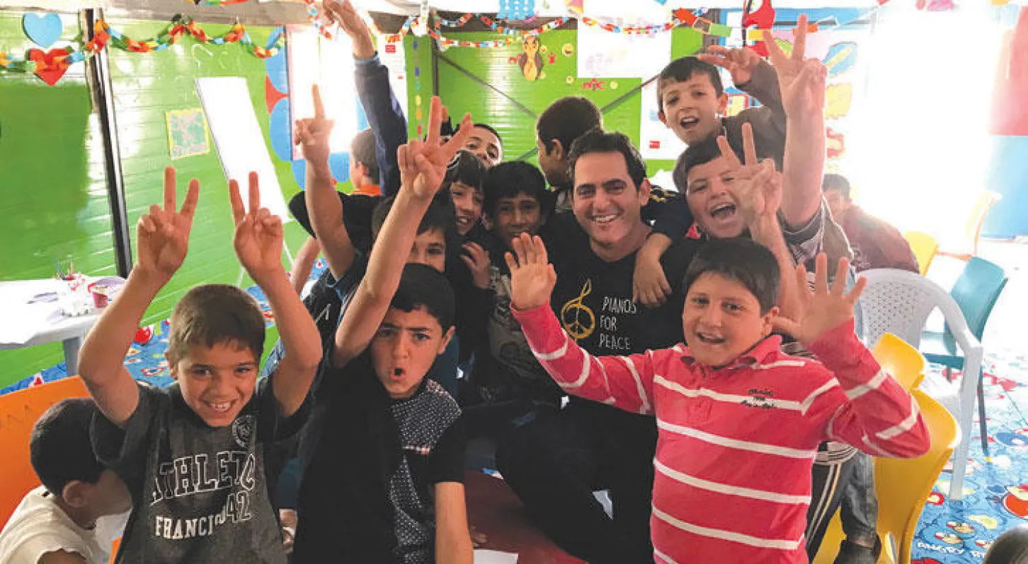الموسيقي مالك جندلي بين أطفال مخيم الزعتري للاجئين السوريين عند زيارته للأردن نهاية مايو الماضي
