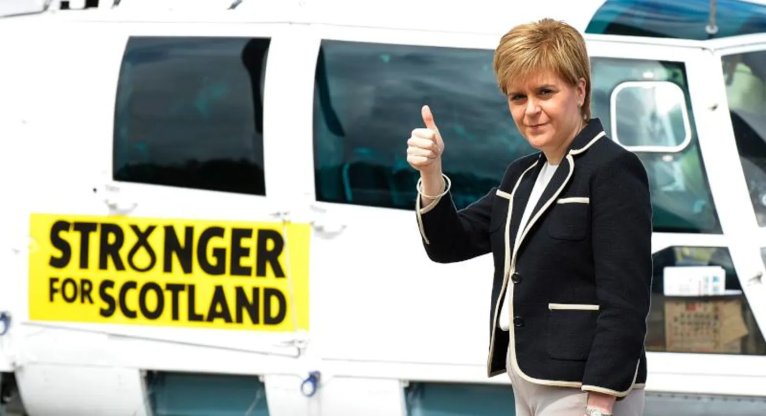 رئيسة وزراء اسكتلندا نيكولا ستيرجن تقف أمام طائرة كتب عليها «معا لاسكتلندا أقوى» (أ.ف.ب)