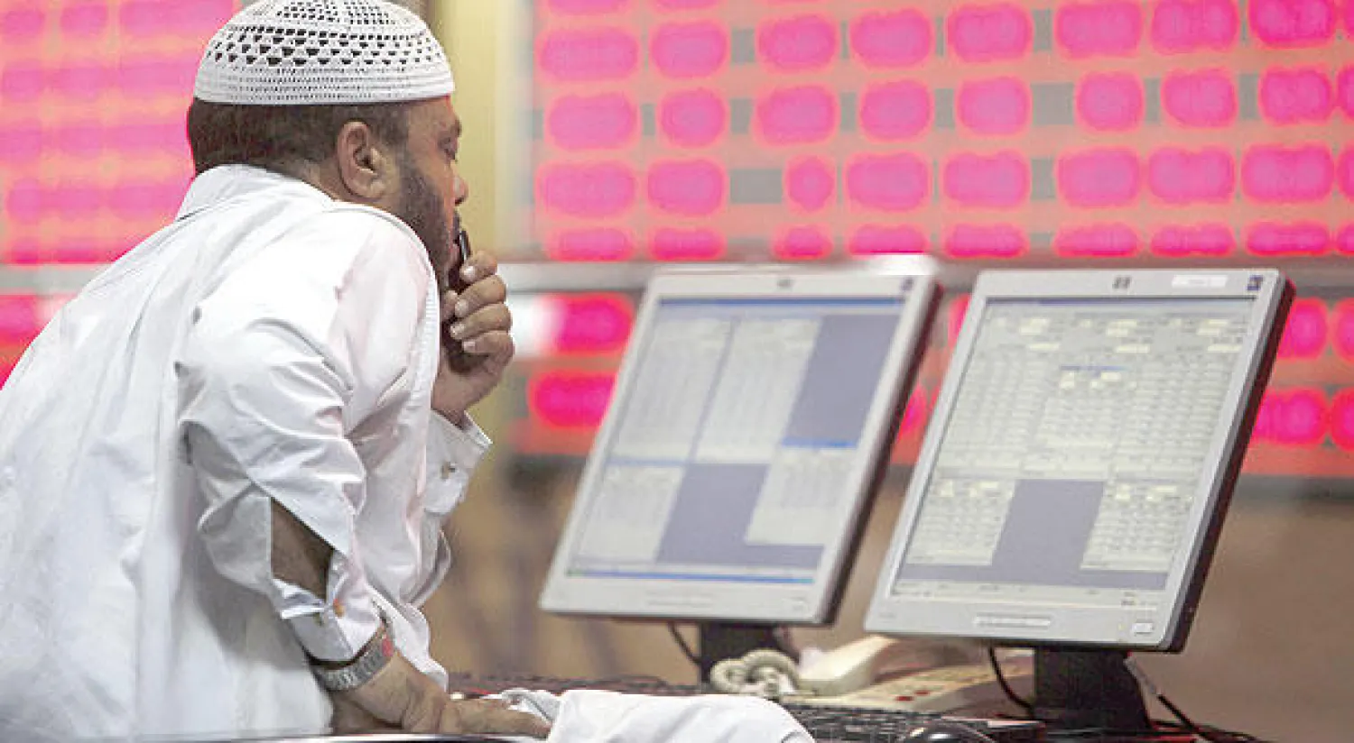 متعامل بالاسهم القطرية يراقب مؤشر الاسهم في بورصة الدوحة (غيتي)