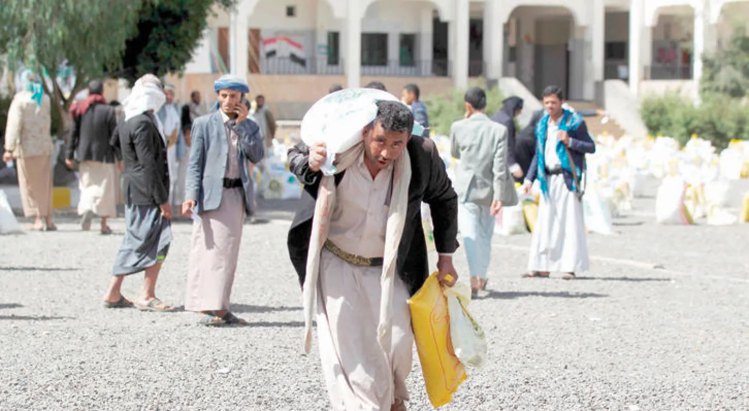 يمني يحمل بعض المواد الغذائية التي وزعتها منظمة إغاثية خيرية بمناسبة شهر رمضان في العاصمة صنعاء أمس (إ.ف.ب)