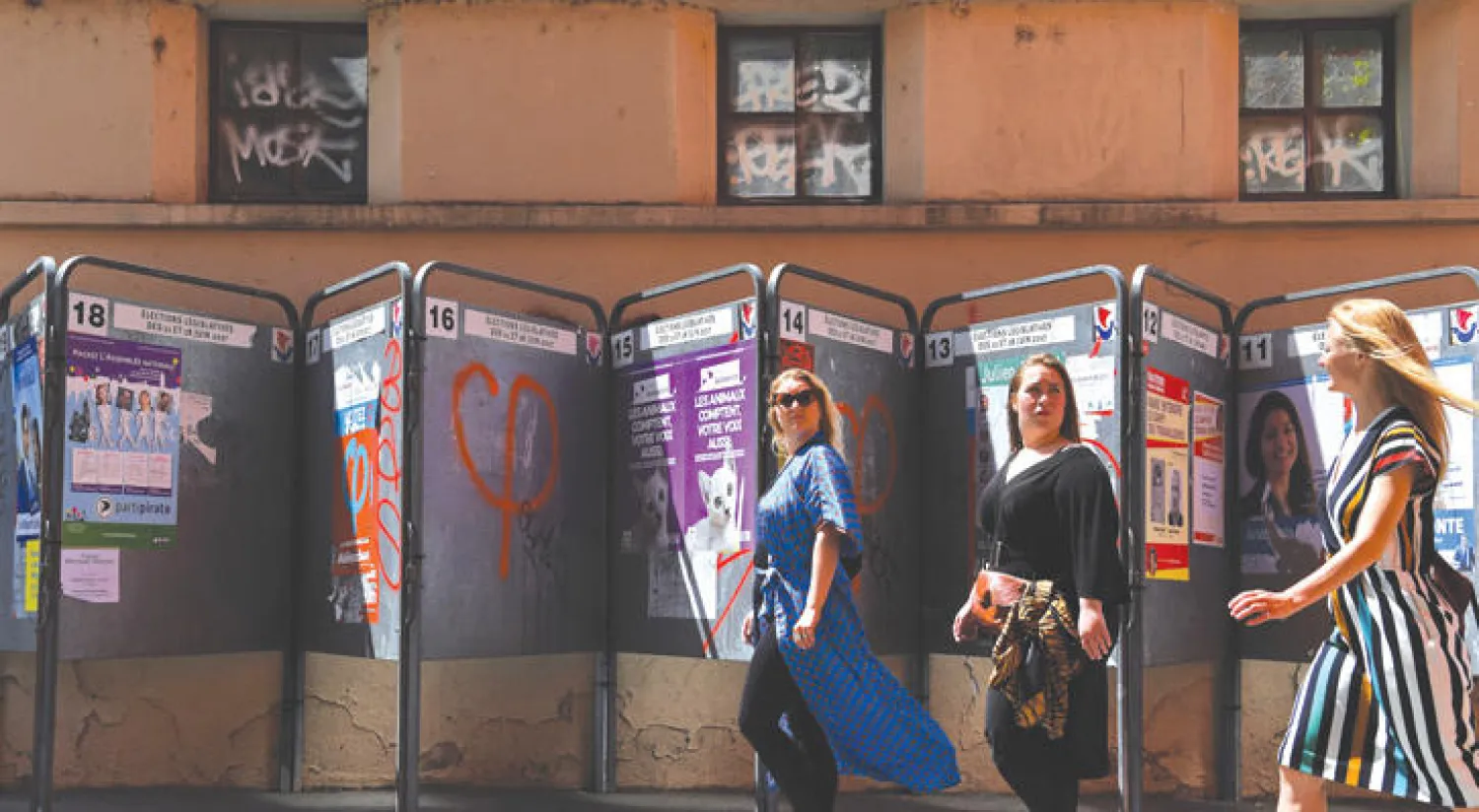 امرأتان تمران أمام ملصقات انتخابية في باريس أمس (غيتي)