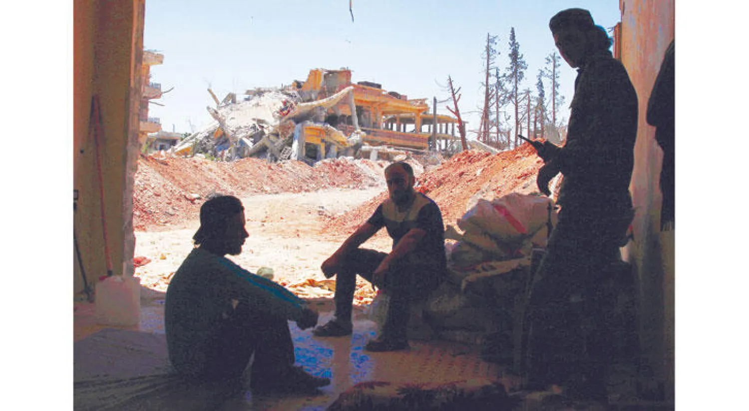 استراحة عناصر من «الجيش السوري الحر» أمس في حي المنشية بدرعا الذي يتعرض لقصف عنيف (رويترز)