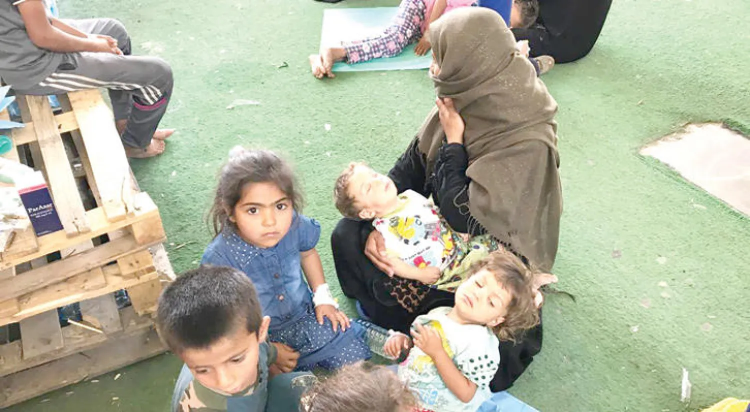أطفال نازحون يفترشون الأرض في أحد مستشفيات أربيل أمس («الشرق الأوسط»)