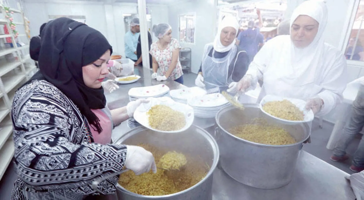 لبنانيات وسوريات يعدون «الإفطار» في بيروت (أ.ف.ب)