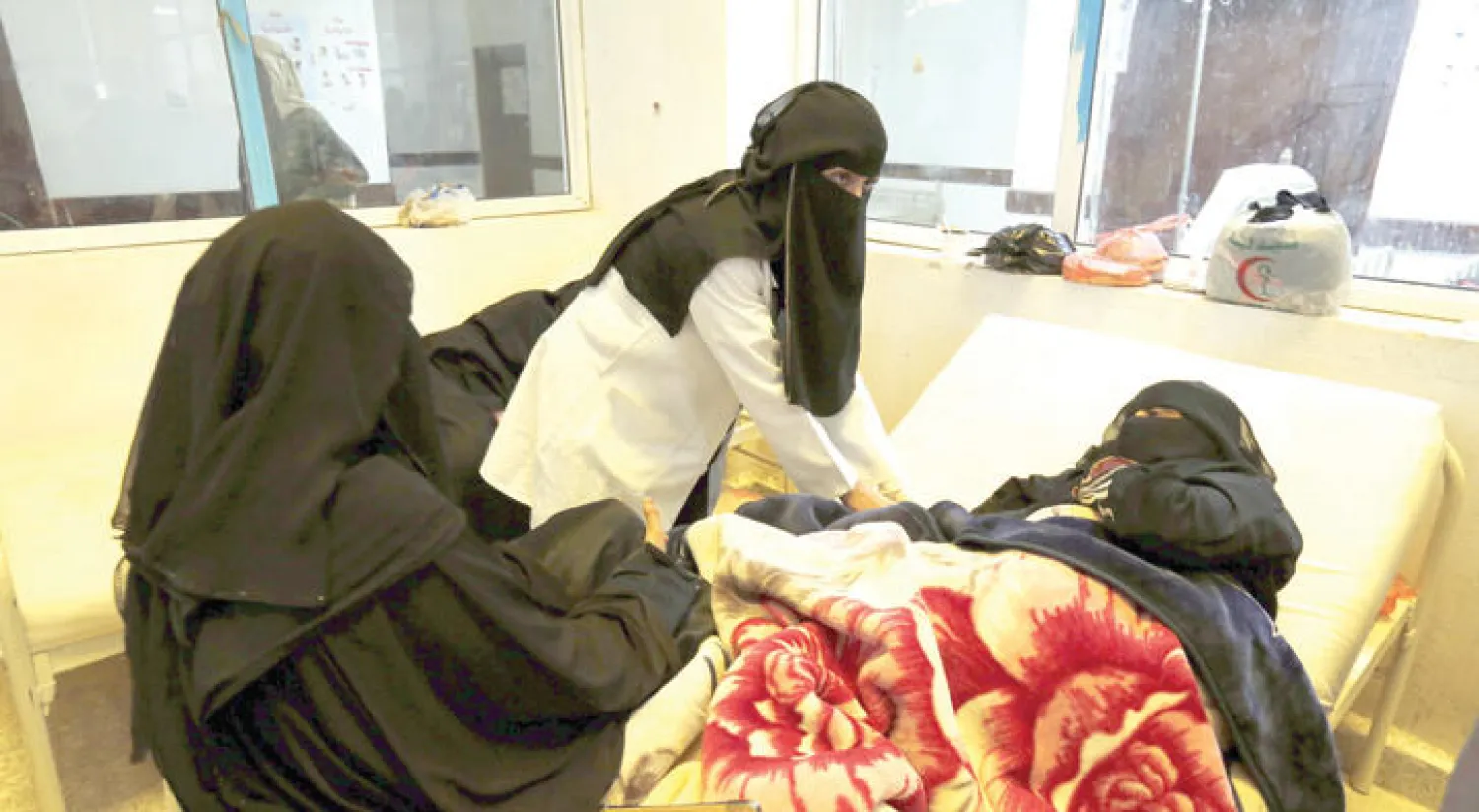 طبيبة يمنية تفحص مريضة يشتبه في إصابتها بالكوليرا في صنعاء (إ.ب.أ)
