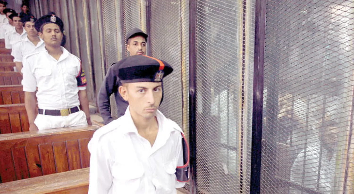 جنود شرطة مصريون بمحكمة الجنايات في حراسة المتهمين أمس في قضية اغتيال النائب العام المصري هشام بركات قبل إحالة أوراقهم إلى مفتي الجمهورية تمهيداً للحكم بإعدامهم (رويترز)