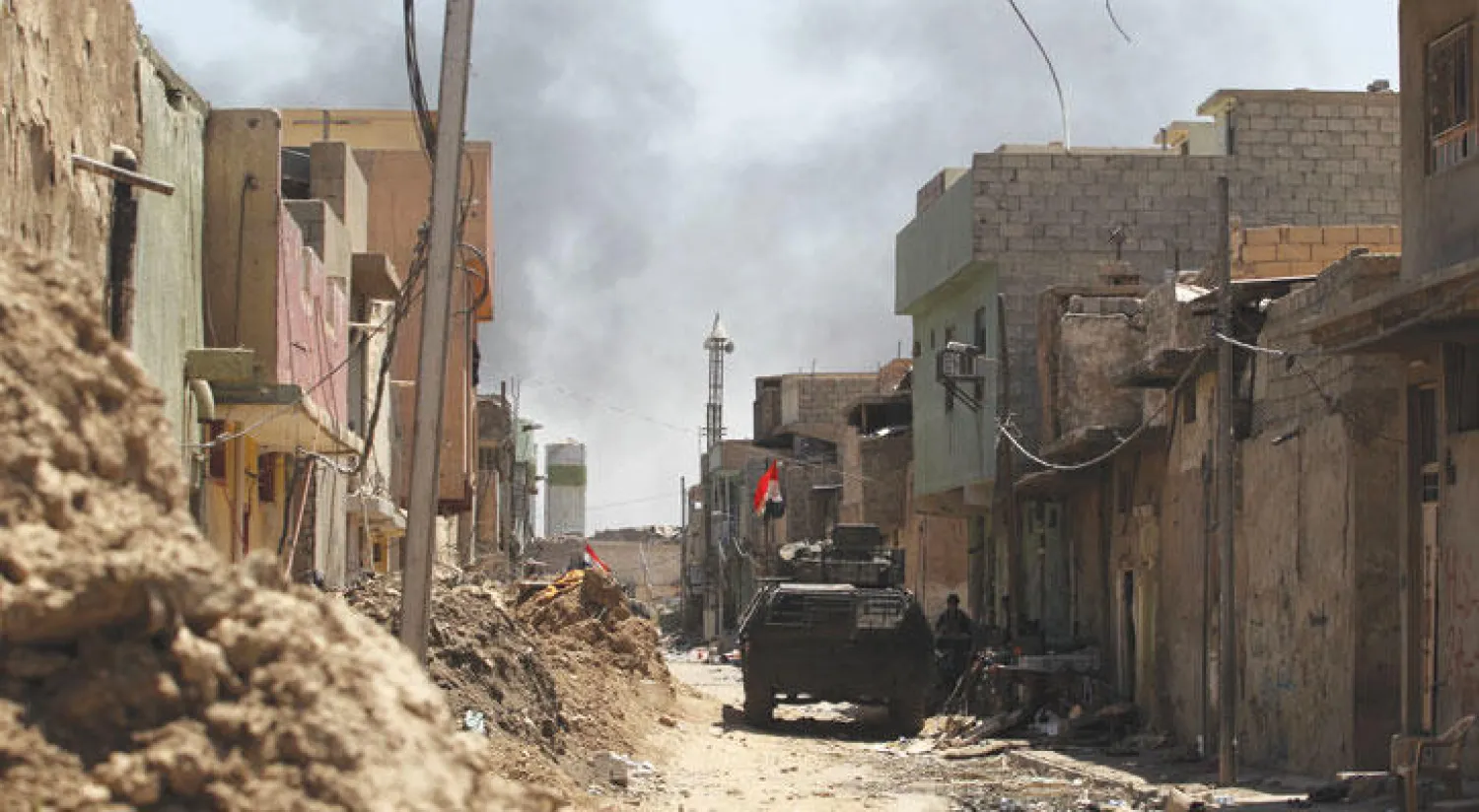 عربة عسكرية تشق طريقها وسط أحد شوارع الموصل القديمة أمس (أ.ف.ب)