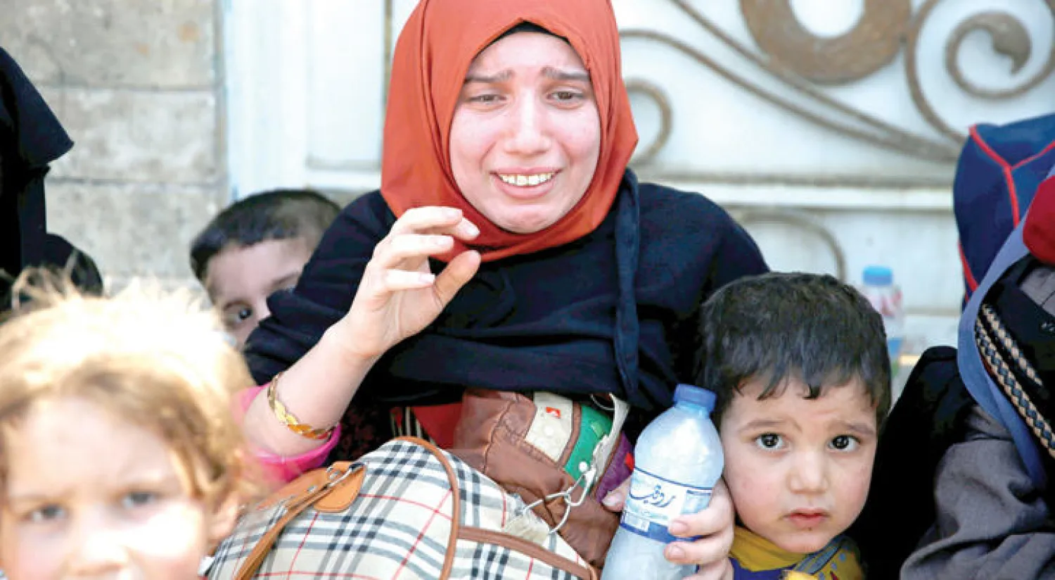 امرأة تبكي بعد أن أنقذتها القوات العراقية مع أطفالها في الموصل القديمة أمس (رويترز)