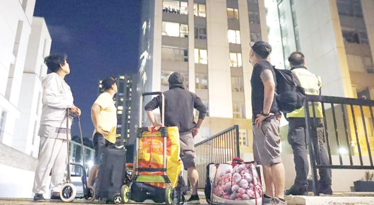 سكان أخلوا برجا سكنيا في بلدية كامدن مساء أول من أمس (إ.ب.أ)