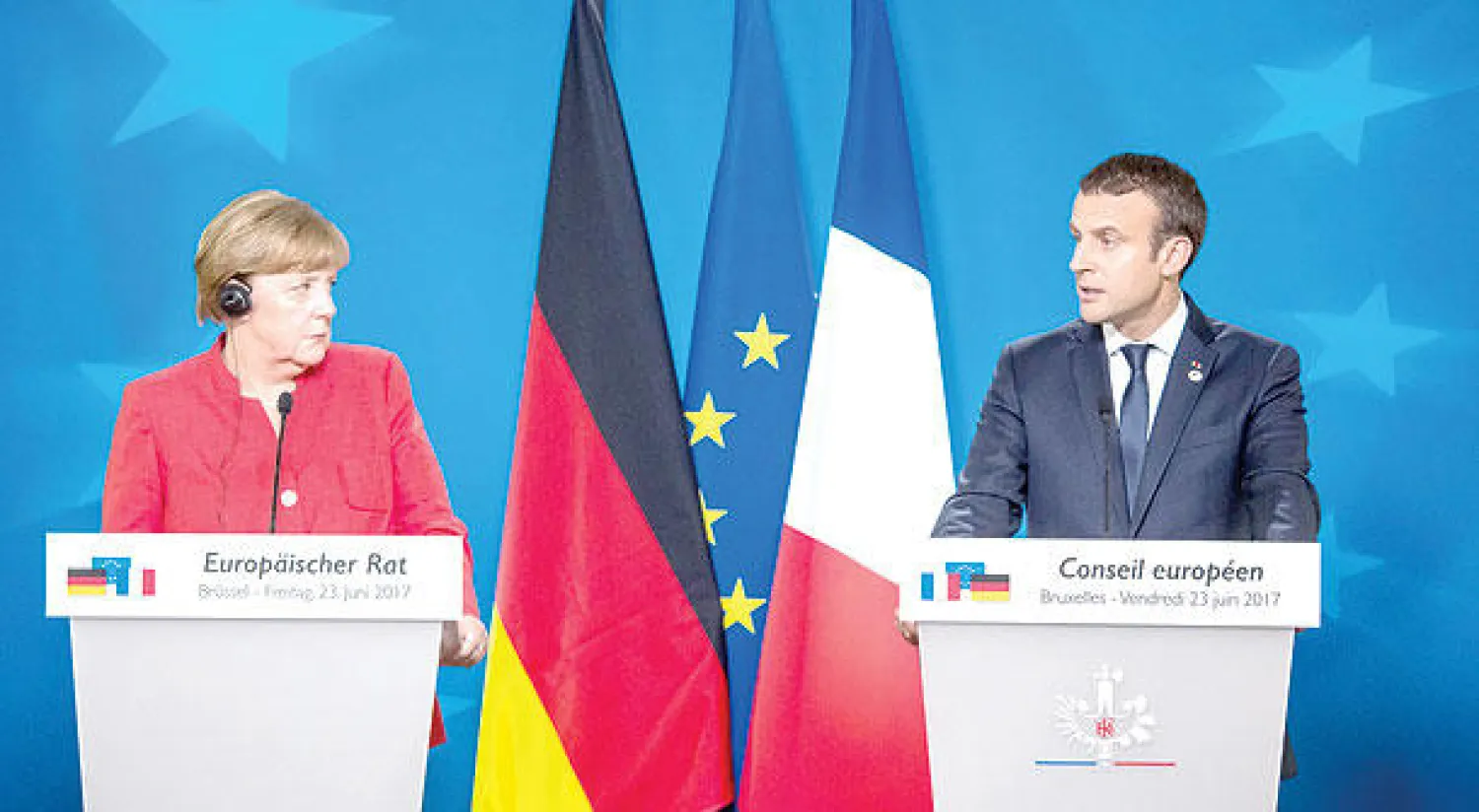 الرئيس الفرنسي إيمانويل ماكرون والمستشارة الألمانية أنجيلا ميركل في مؤتمرهما الصحافي في بروكسل أول من أمس (أ.ف.ب)