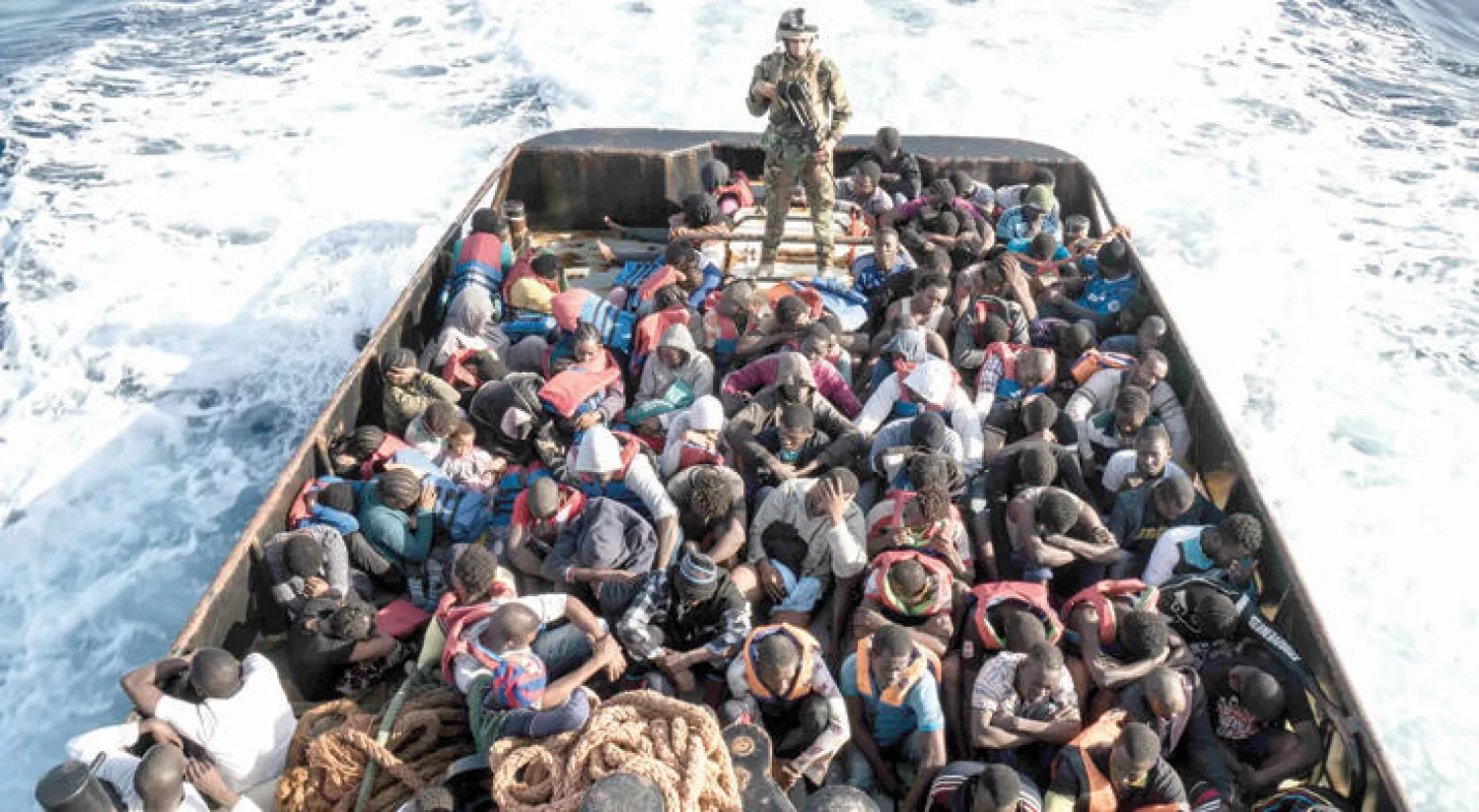 أحد حراس السواحل الليبيين في مركب يحمل مهاجرين حاولوا الوصول إلى الشواطئ الأوروبية (أ.ف.ب)