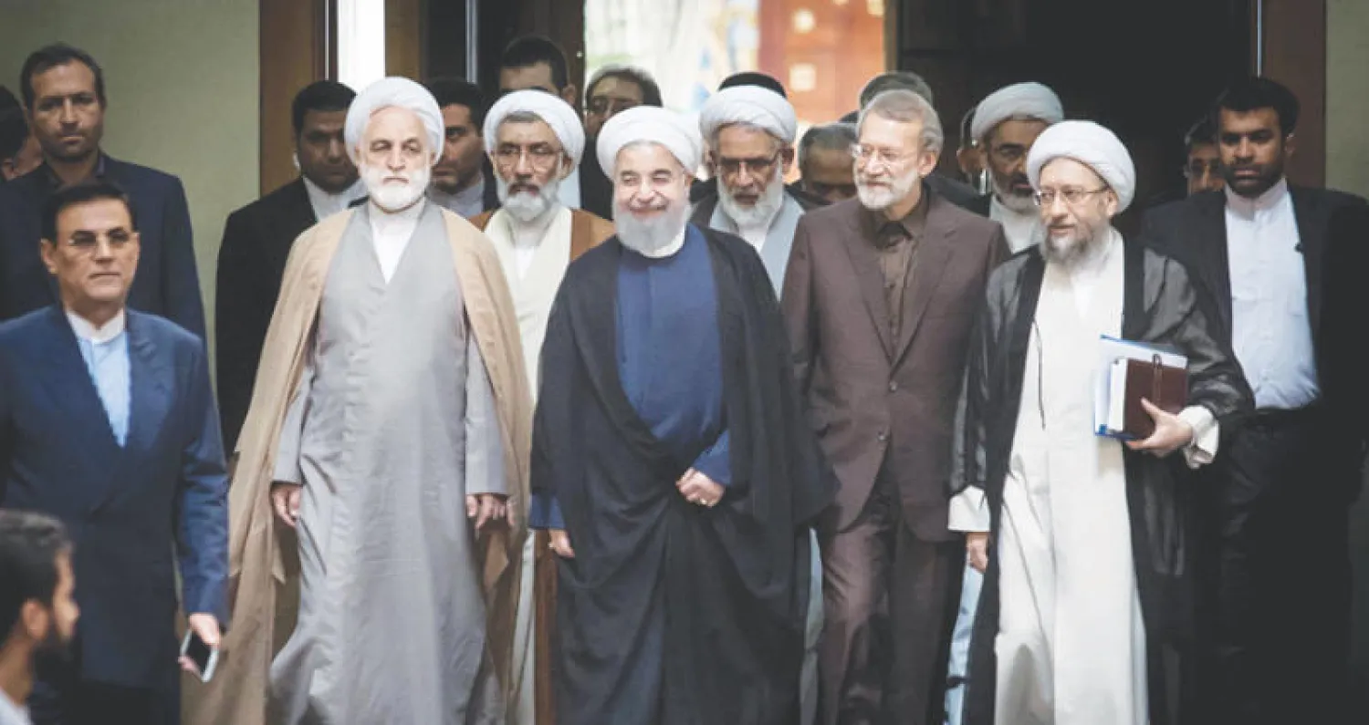 حسن روحاني يتوسط علي وصادق لاريجاني والمتحدث باسم القضاء غلام حسين أجئي قبل المؤتمر في طهران أمس (مهر)