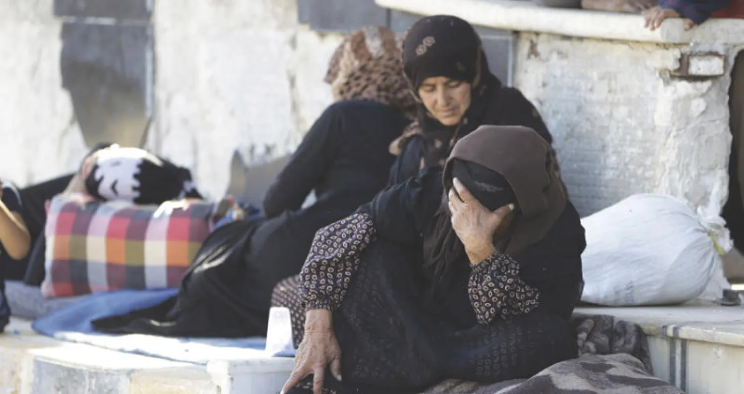 نازحات هربن من مناطق سيطرة {داعش} في الرقة ودير الزور داخل محطة حافلات بحلب اول من امس (أ.ف.ب)