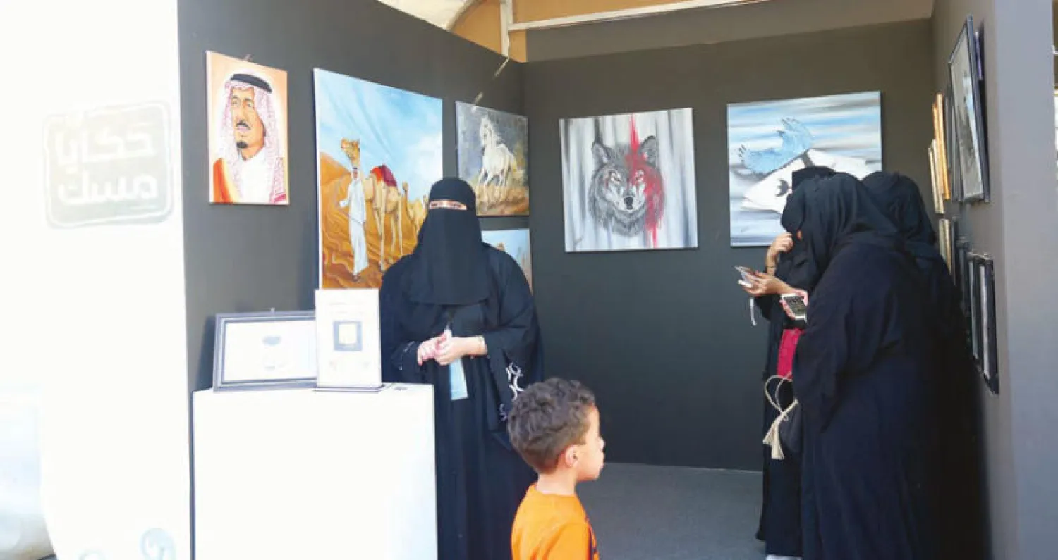 إحدى الفنانات تعرض لوحاتها الإبداعية في سوق حكايا مسك