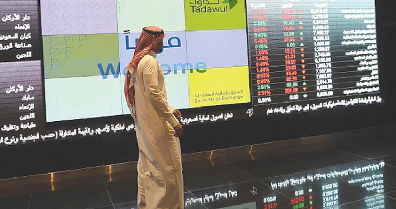 مستثمر سعودي يراقب مؤشر البورصة في الرياض (أ.ف.ب)