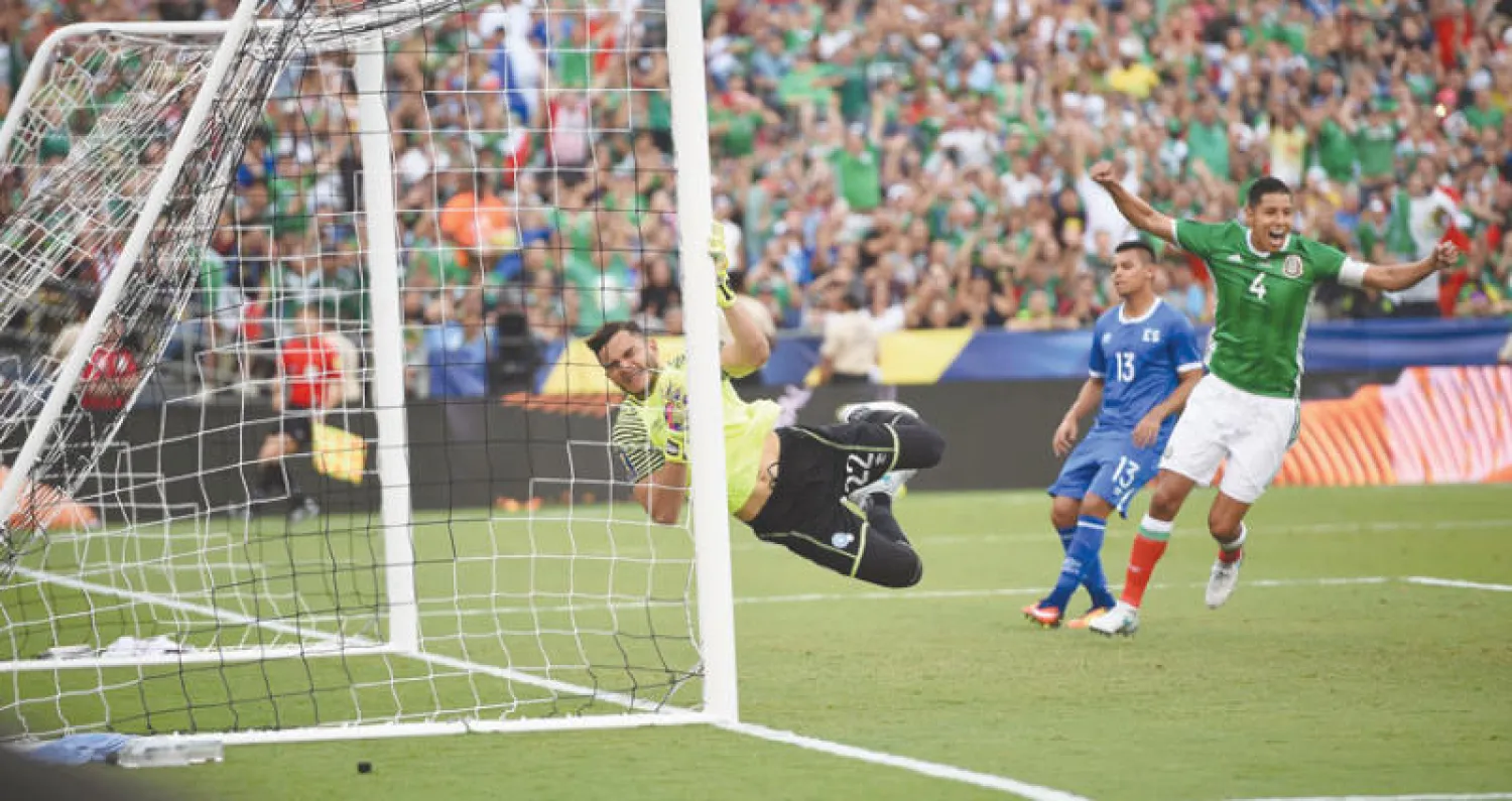 فيلابوس حارس السلفادور في محاولة يائسة للتصدي لكرة المكسيكي مارين التي هزت شباكه (أ.ف.ب)