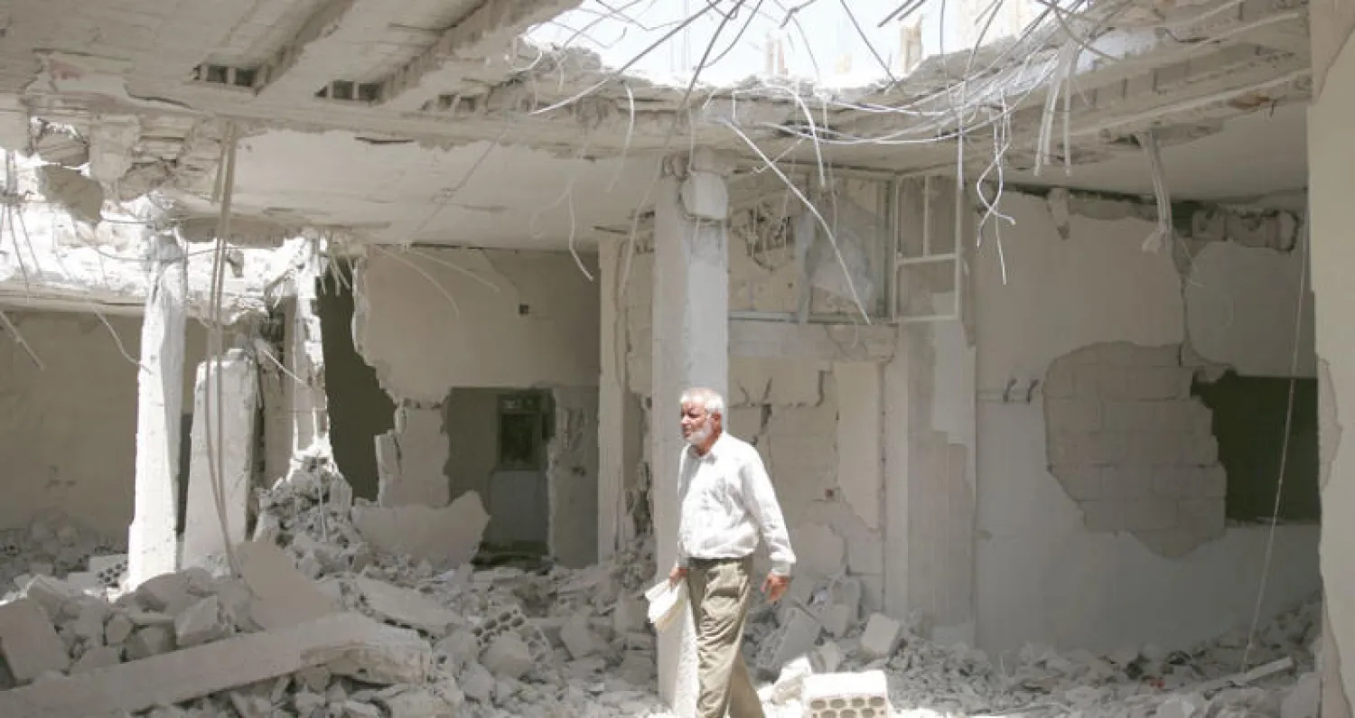 مسن من سكان درعا يتفقد مبنى مدمرا في المحافظة أمس (رويترز)