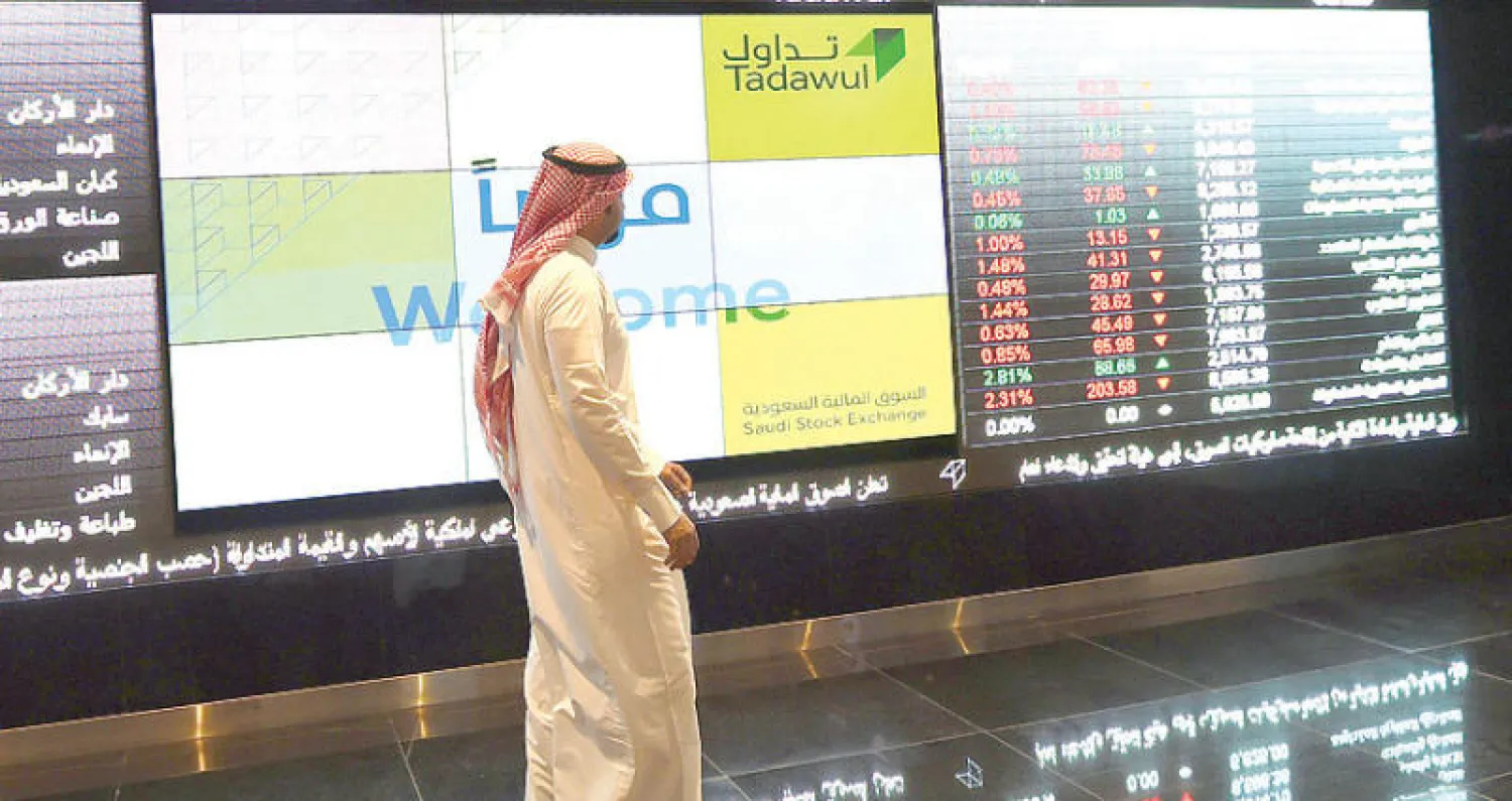 متعامل سعودي يتابع حركة الأسهم عبر لوحة مؤشرها في الرياض (أ.ف.ب)