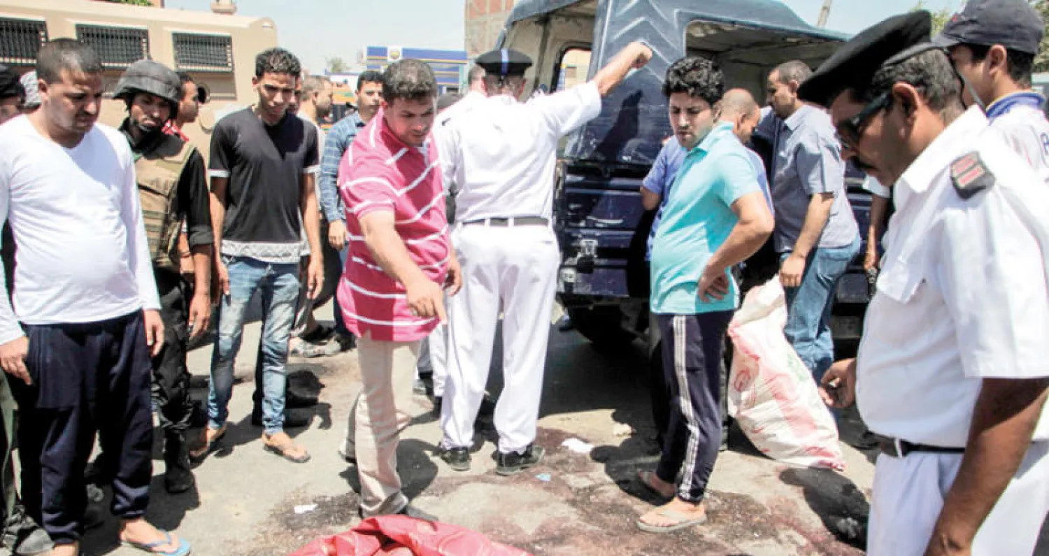 رجال الشرطة الجنائية يعاينون آثار الحادث الإرهابي الذي تعرض له كمين أمني في البدرشين بالجيزة أمس (أ.ف.ب)