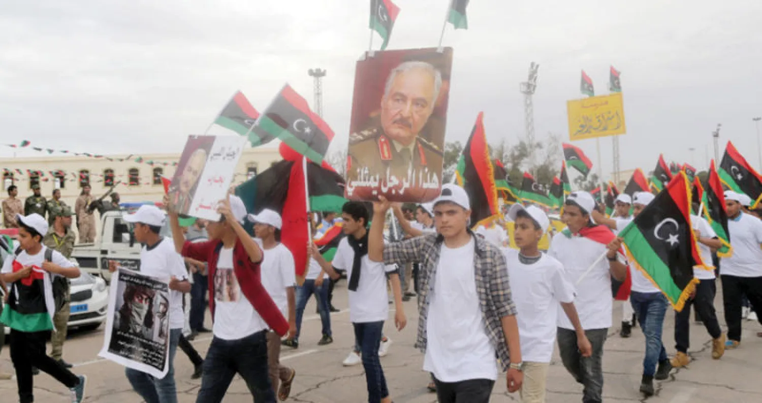 ليبيون يحملون صورة لحفتر في مسيرة أحتفالا بذكرى مرور ثلاث سنوات للجيش الليبي بمحاربة الإرهاب (رويترز)