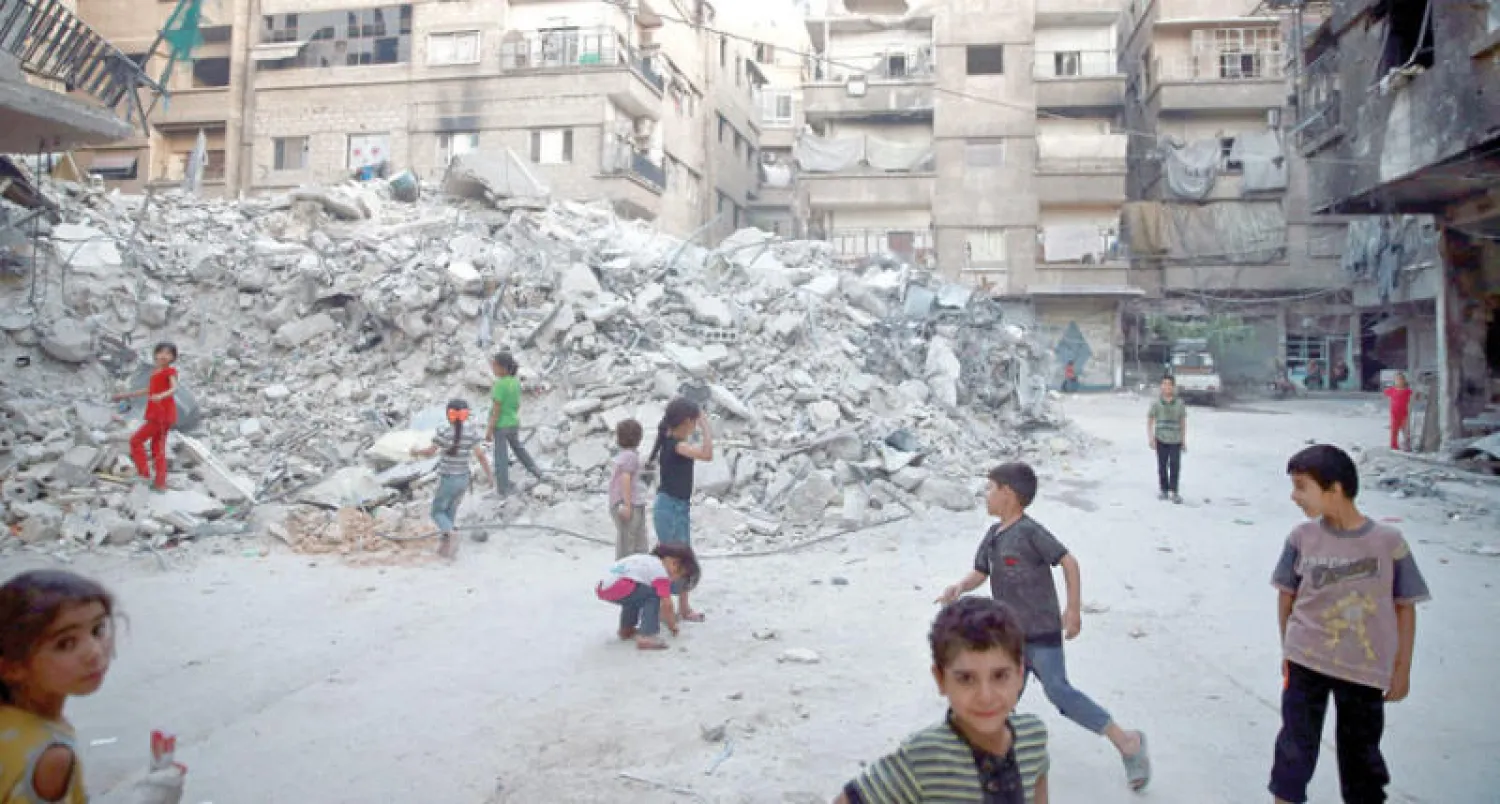 أطفال يلهون في بلدة عين ترما بريف الغوطة الشرقية قرب دمشق أول من أمس (رويترز)