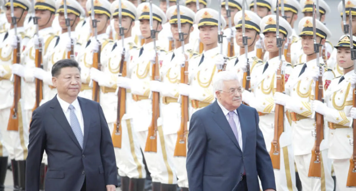 الرئيسان الصيني شي جينبينغ والفلسطيني محمود عباس يستعرضان حرس الشرف في قصر الشعب ببكين أمس (رويترز)