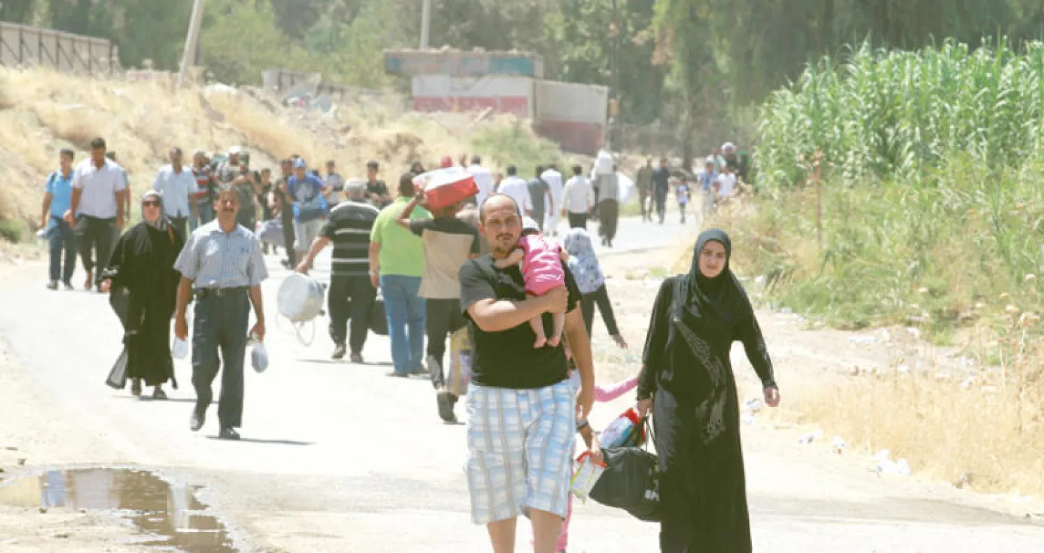 موصليون يسيرون أمس نحو جسر عائم يربط شرق الموصل بغربها (رويترز)