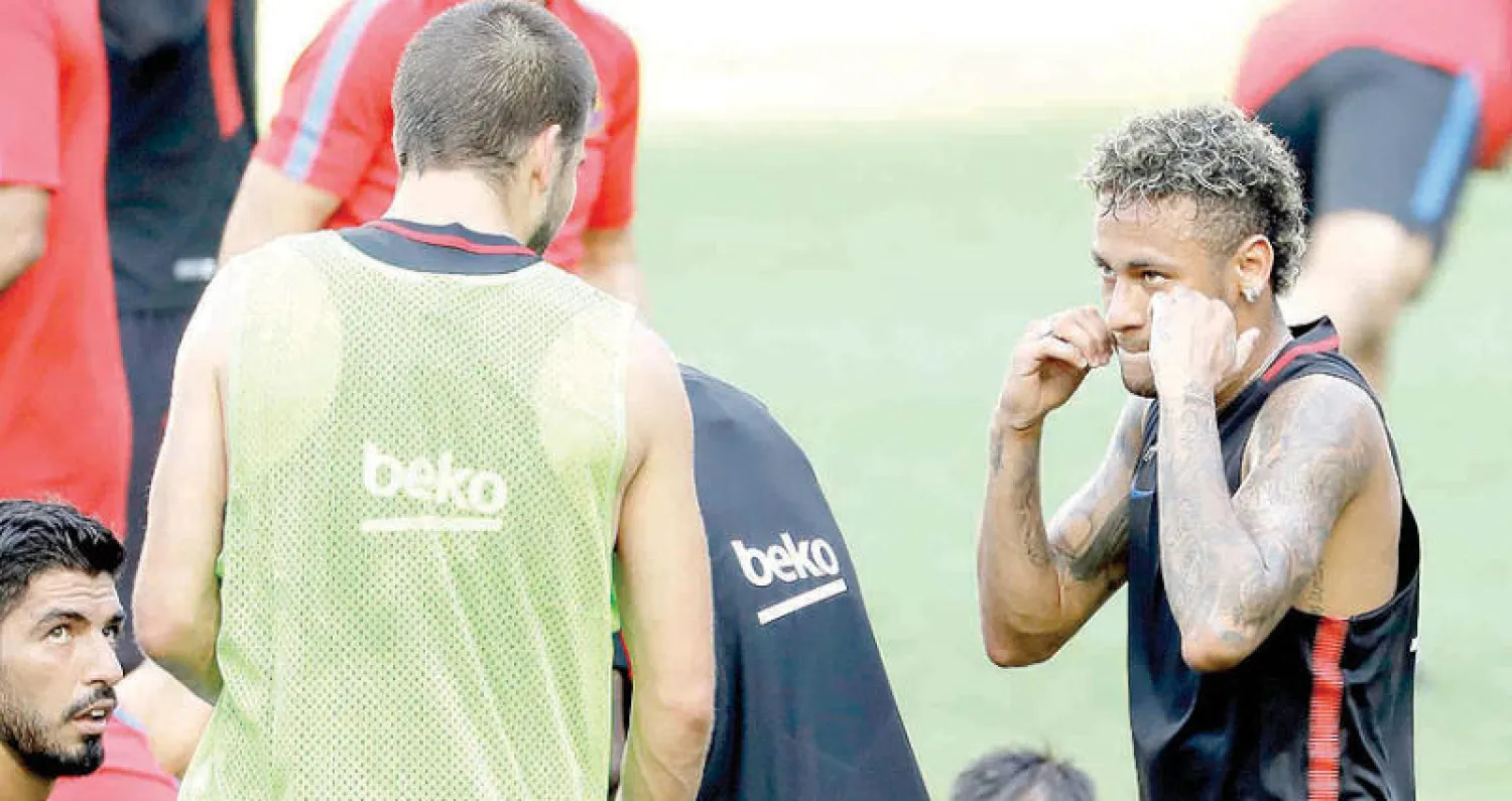 نيمار يمزح مع زميله بيكيه ويدعوه للملاكمة في تدريب أمس (أ.ب)