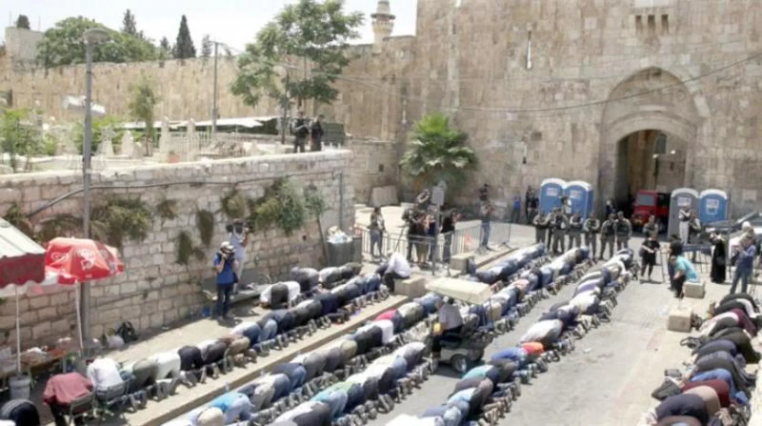 فلسطينيون يؤدون الصلاة خارج باب الأسباط (باب الأسود) في القدس القديمة وسط إجراءات أمنية مشددة (أ.ب)