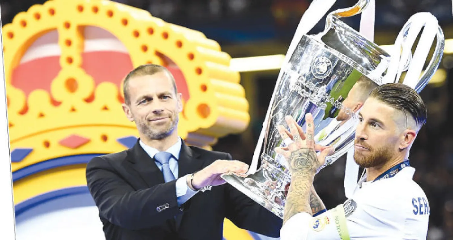 ألكسندر تشيفرين رئيس الاتحاد الأوروبي  لكرة القدم يسلم كأس الأبطال لراموس قائد ريال مدريد (إ.ب.أ)