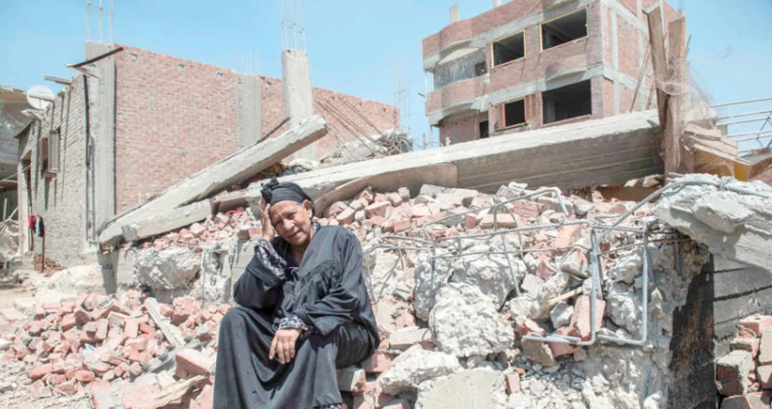 مصرية تجلس على أنقاض منزلها الذي هدمته السلطات في إطار سياسة استرجاع ممتلكات الدولة في جزيرة الوراق على النيل قرب القاهرة (أ.ف.ب)