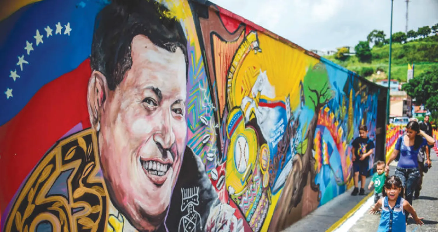 لوحة جدارية للرئيس السابق هوغو شافيز قرب متحف يضم رفاته في ضاحية قريبة من كراكاس التي تشهد احتجاجات ضد انتخابات الجمعية التأسيسية المقررة اليوم (أ.ف.ب)