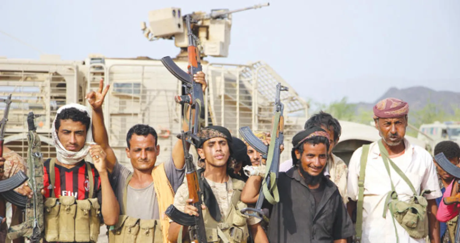 مقاتلون من الحكومة اليمنية الشرعية يحتفلون بالنصر في أعقاب تحرير معسكر خالد الاستراتيجي بمحافظة تعز (إ.ب.أ)