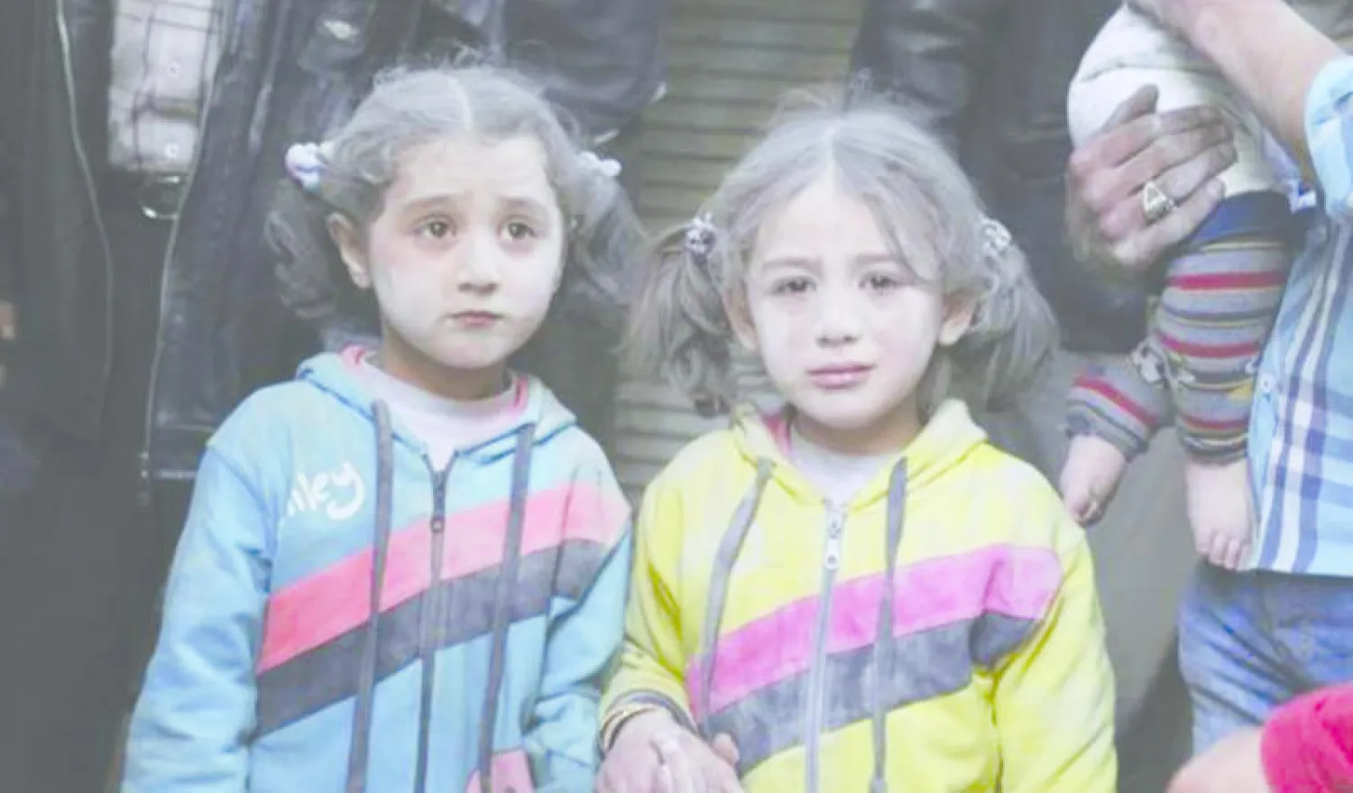 طفلتان سوريتان تظهر عليهما آثار الصدمة والغبار بعد القصف (رويترز)