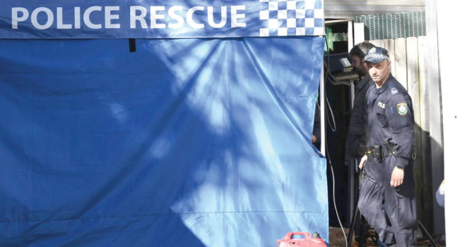 ضابط شرطة أسترالي يقف أمام مدخل منزل أحد المشتبه بتورطهم في المحاولة في نيوساوث ويلز (إ.ب.أ)