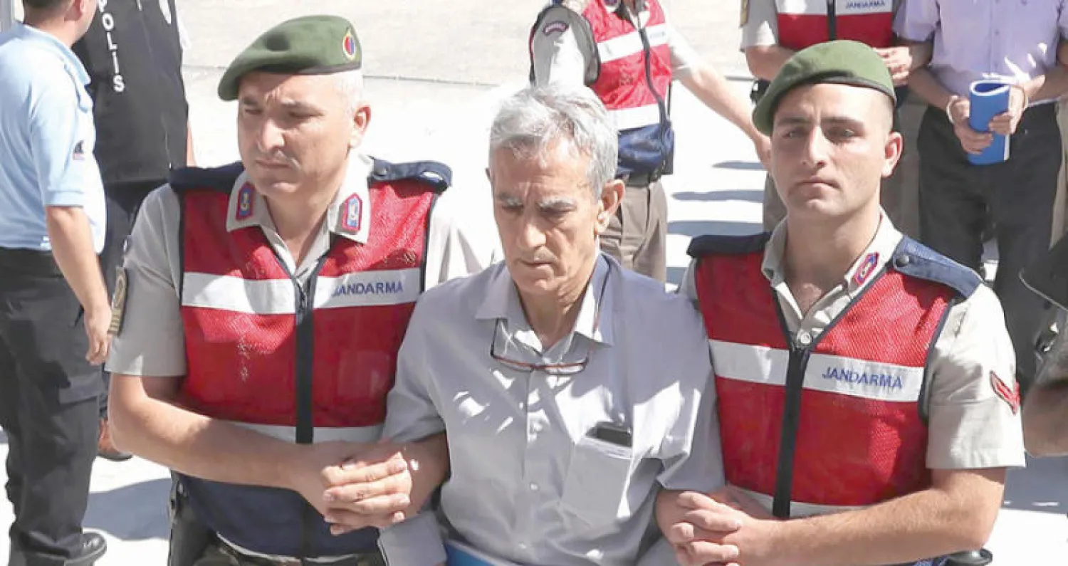 قائد القوات الجوية السابق أكين أوزتورك في طريقه إلى المحكمة أمس متهماً في محاولة الانقلاب (أ.ف.ب)