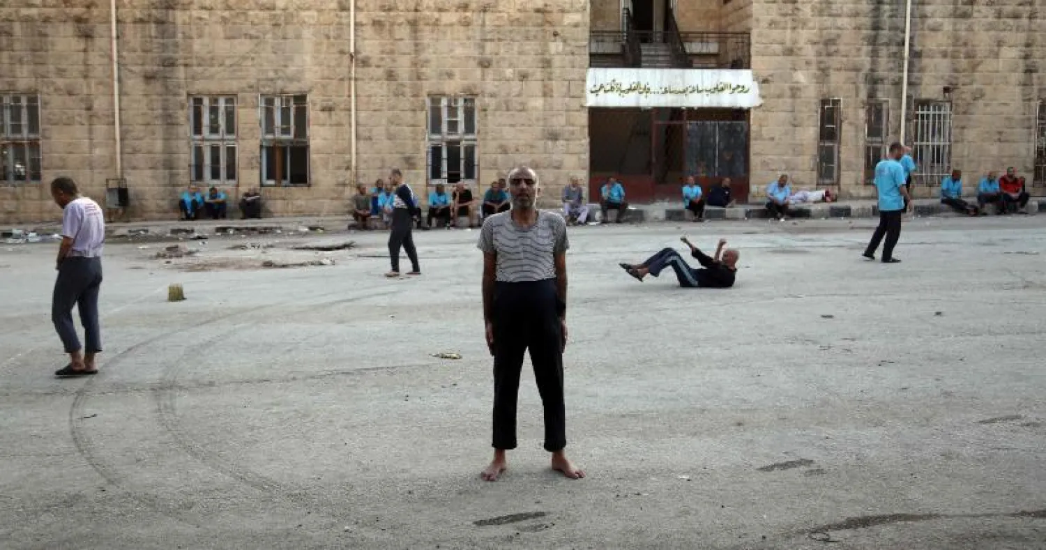 مرضى سوريون يتجولون حول ساحة في عيادة للصحة العقلية في بلدة عزاز بالقرب من الحدود مع تركيا (أ.ف.ب)